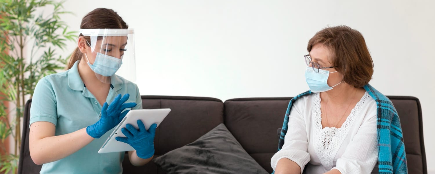Speech-language pathologist using a tablet to assess a patient’s recovery progress