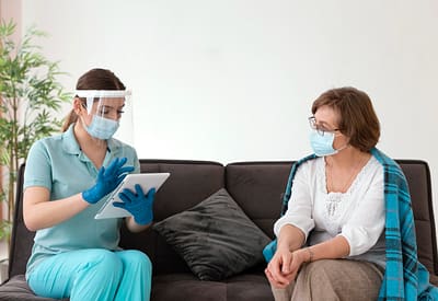 Speech-language pathologist using a tablet to assess a patient’s recovery progress